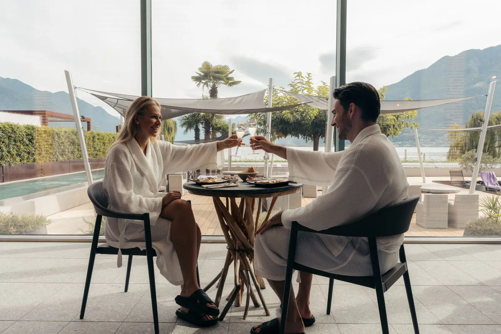 Zwei Gäste im Bademantel stossen auf der Terrasse von Termali Salini in Locarno am Lago Maggiore an